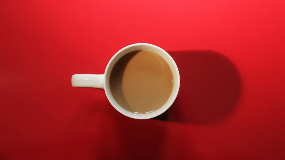 赤いテーブルの白いコーヒーカップ